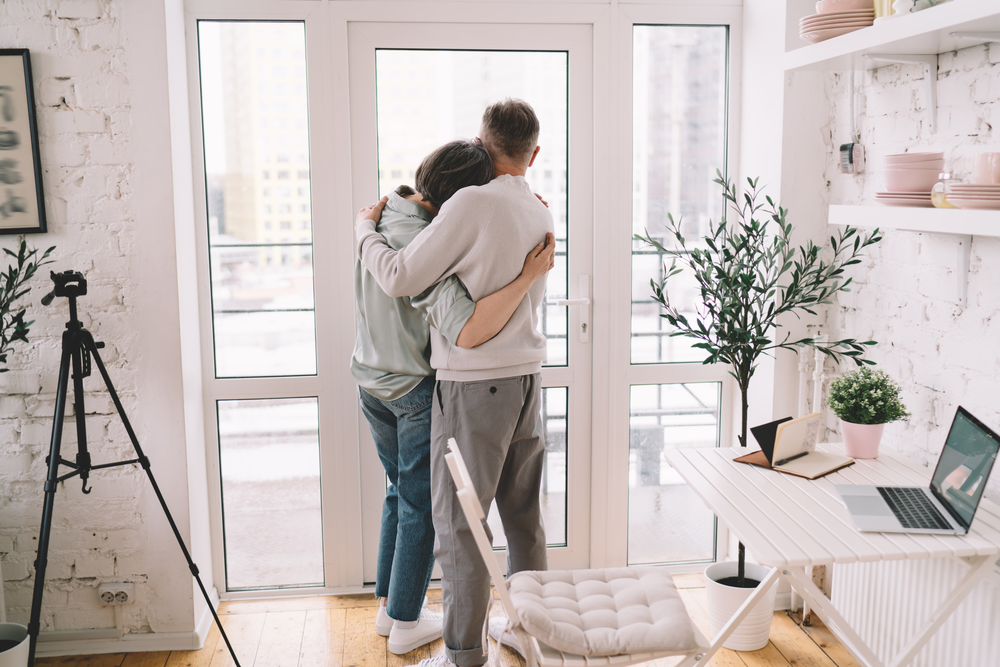 Unrecognizable copuple higging while looking out of IFB